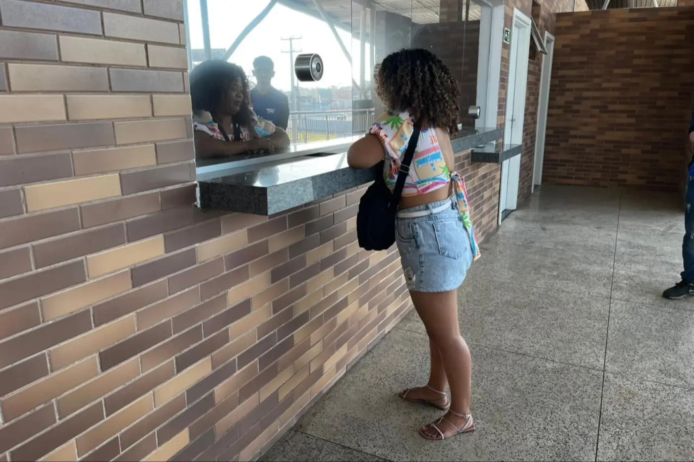 Usuária na bilheteria do BRT Metropolitano
